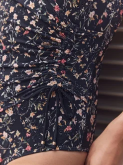 Badkleding|Next Zwart met broderie en fijne print - Badpak met vormgevende zijrimpeling en buikcorrectie