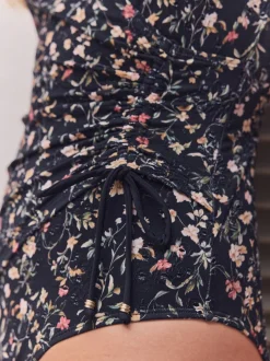 Badkleding|Next Zwart met broderie en fijne print - Badpak met vormgevende zijrimpeling en buikcorrectie